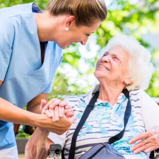 Altenpflegerin hält die Hand einer Seniorin (Symbolbild)